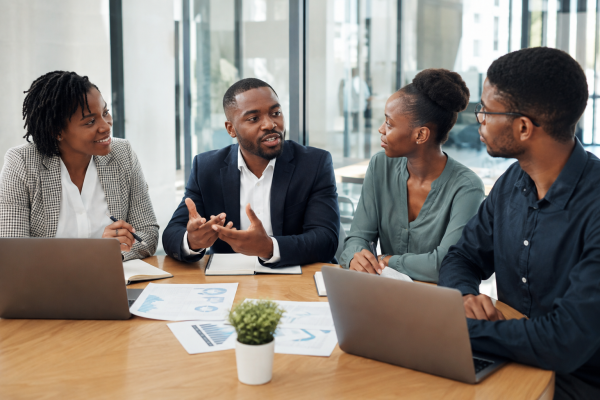 Four HR and business professionals discussing workforce strategy around a table in a modern office.